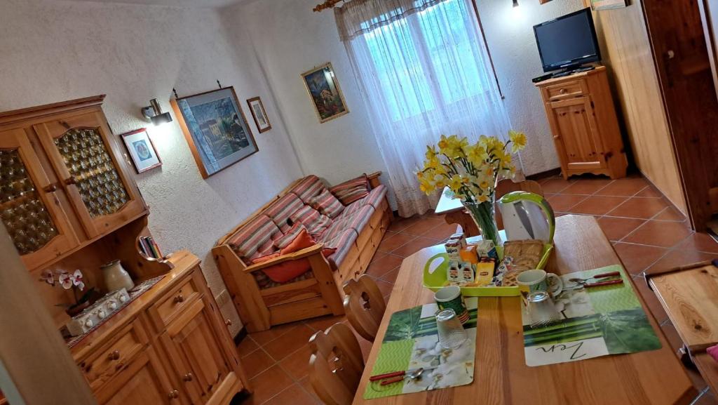 uma sala de estar com uma mesa e um sofá em Residenze Bucaneve - Casa Costa em Tonezza del Cimone