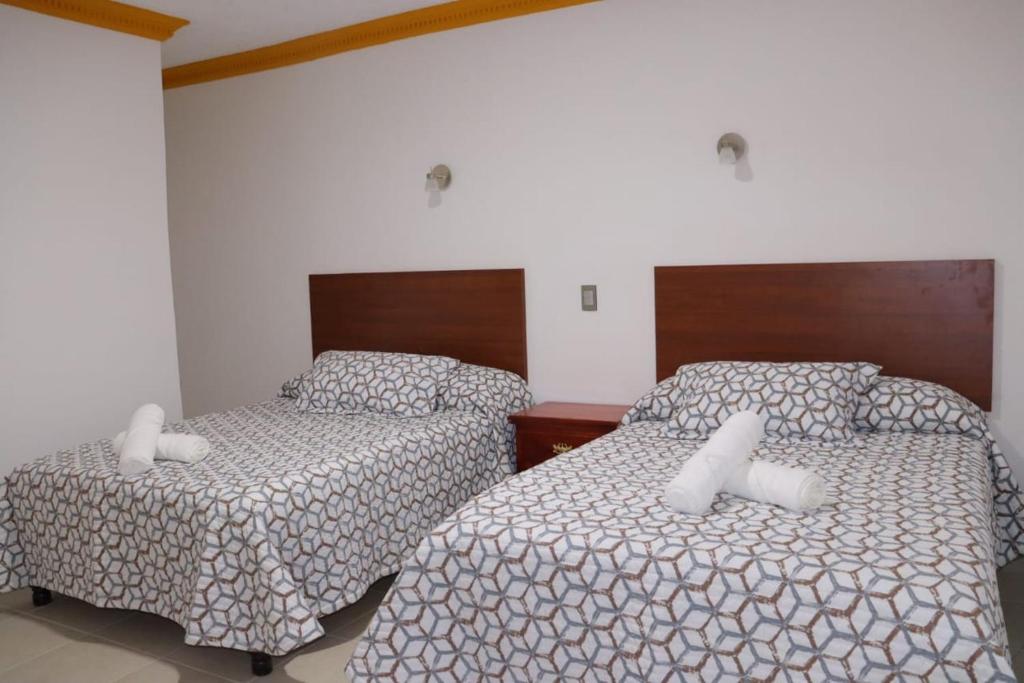 a bedroom with two beds with white pillows at HOTEL CASA MEXICO in Dolores Hidalgo