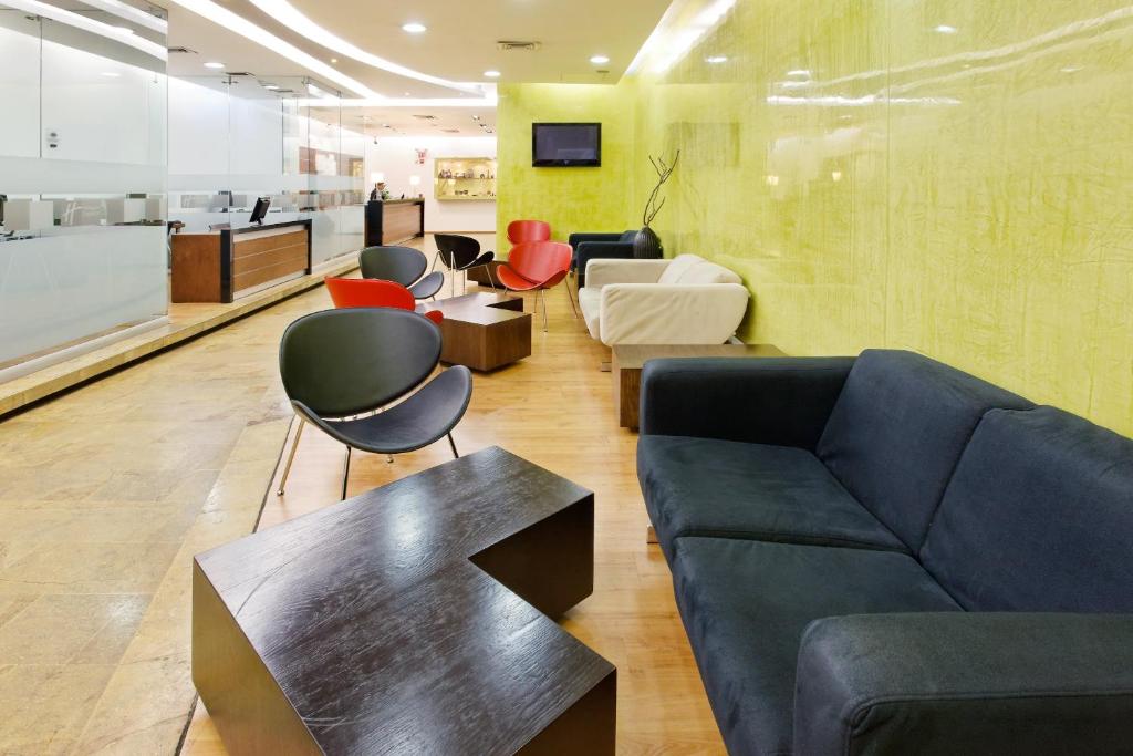 a living room with a couch and chairs at Hotel Holiday Inn Express & Suites Medellin, an IHG Hotel in Medellín