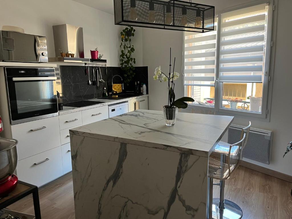 a kitchen with a marble counter top in a room at Entre Lac et Mer in Clermont-lʼHérault