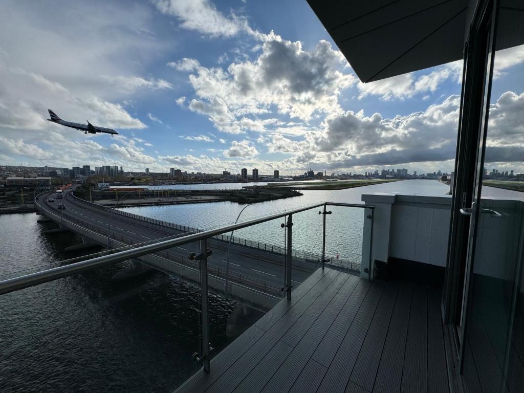 an airplane is flying over a river with a bridge at Seaside Serenity Haven in London