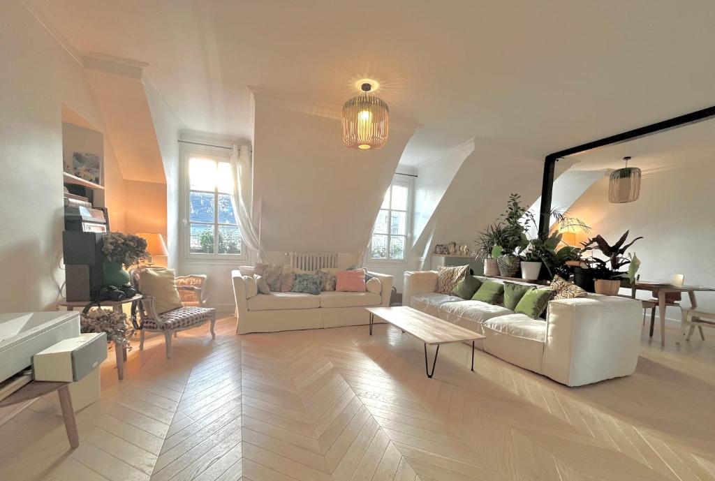 - un salon avec deux canapés blancs et une table dans l'établissement Appartement cosy à Paris 130 m² avec projecteur !, à Paris