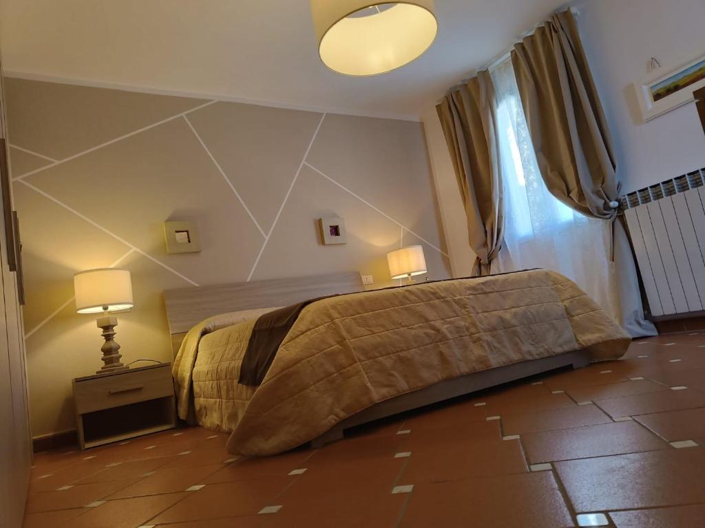 - une chambre avec un lit, deux lampes et une fenêtre dans l'établissement La casetta del poggio, à Poggio a Caiano