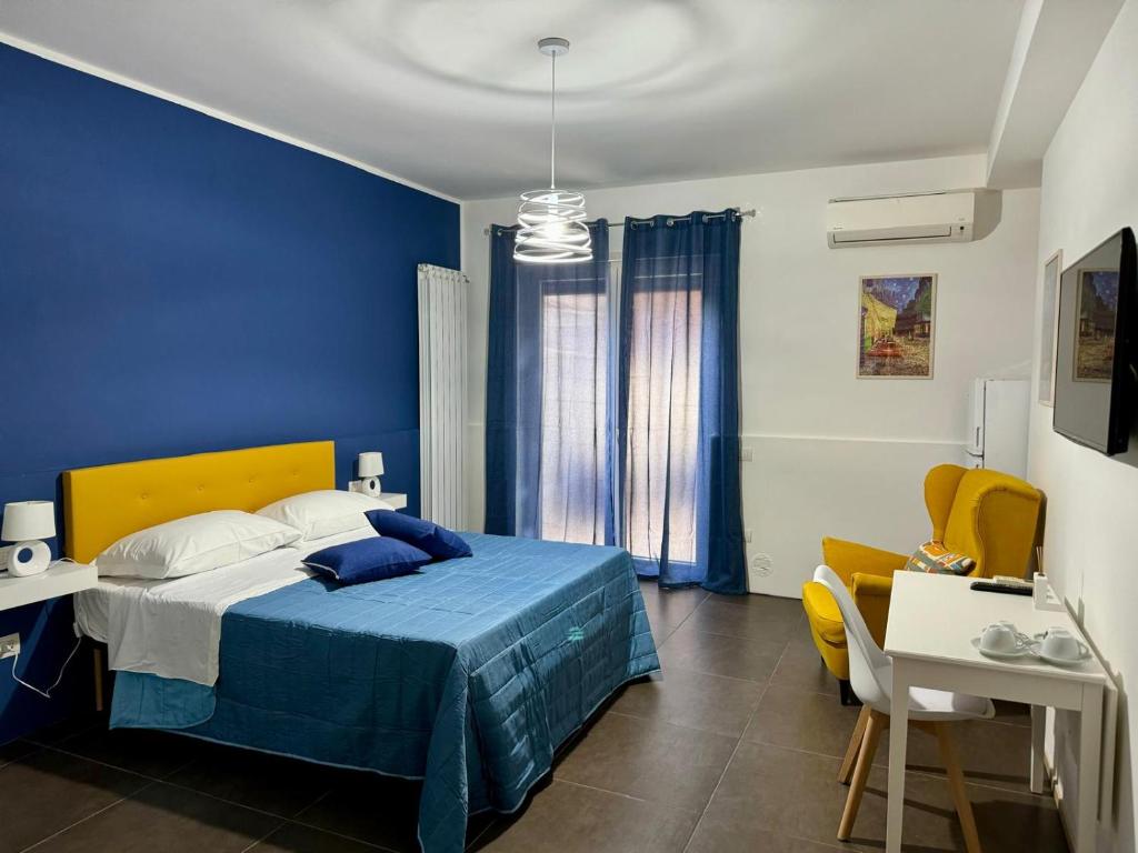 a blue bedroom with a bed and a table at IL RUGGI BB in Salerno