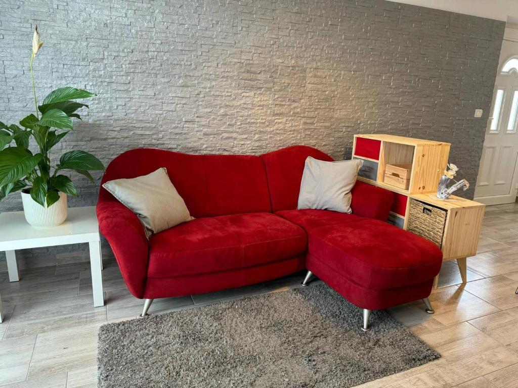 un sofá rojo sentado en una sala de estar en Casa Relax Immersa Nel Verde, en Manzano