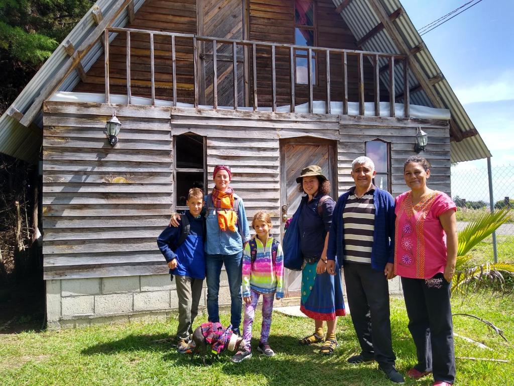 a family poses in front of a house at La morada del amigo in La Trinitaria