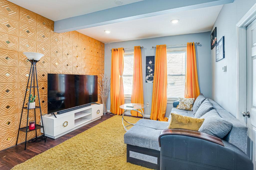 a living room with a blue couch and a flat screen tv at Updated Linden Home Visit NYC and Newark! in Linden