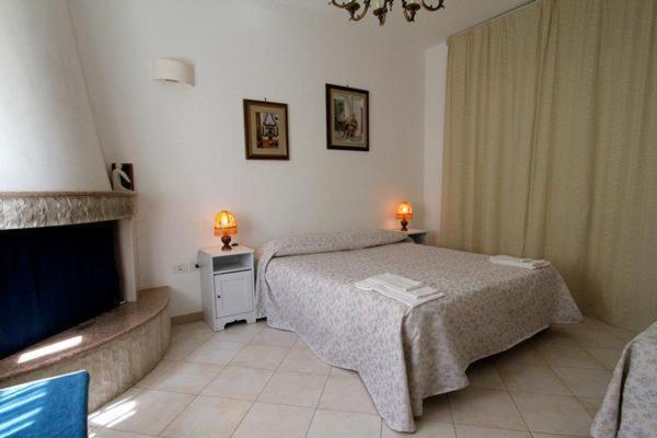 プティニャーノにあるB&B Il Bambùのベッドと暖炉付きのホテルルーム