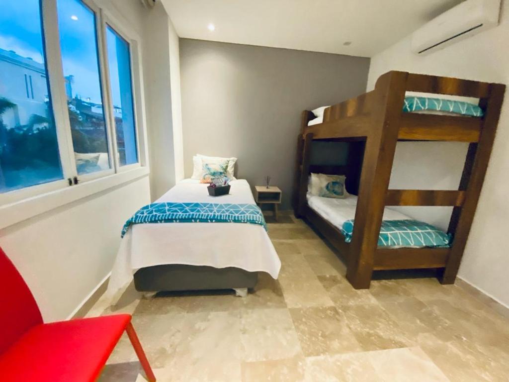 niewielka sypialnia z łóżkiem piętrowym i czerwonym krzesłem w obiekcie Sientoonce w mieście Cartagena de Indias