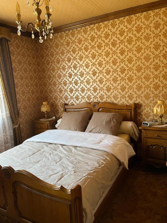 a bedroom with a large bed and two night stands at Spacieuse maison de village in Luché-Pringé