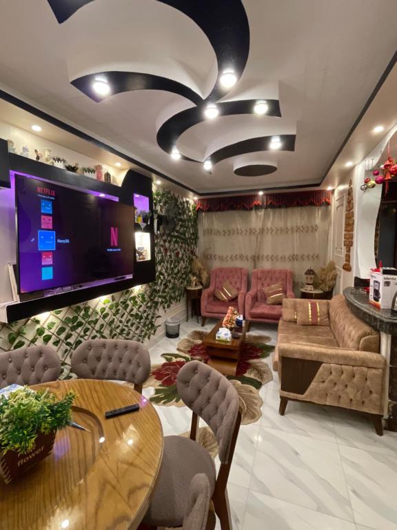 een woonkamer met een grote tv en een tafel bij Cozy Flat near downtown Almorsi in Alexandrië