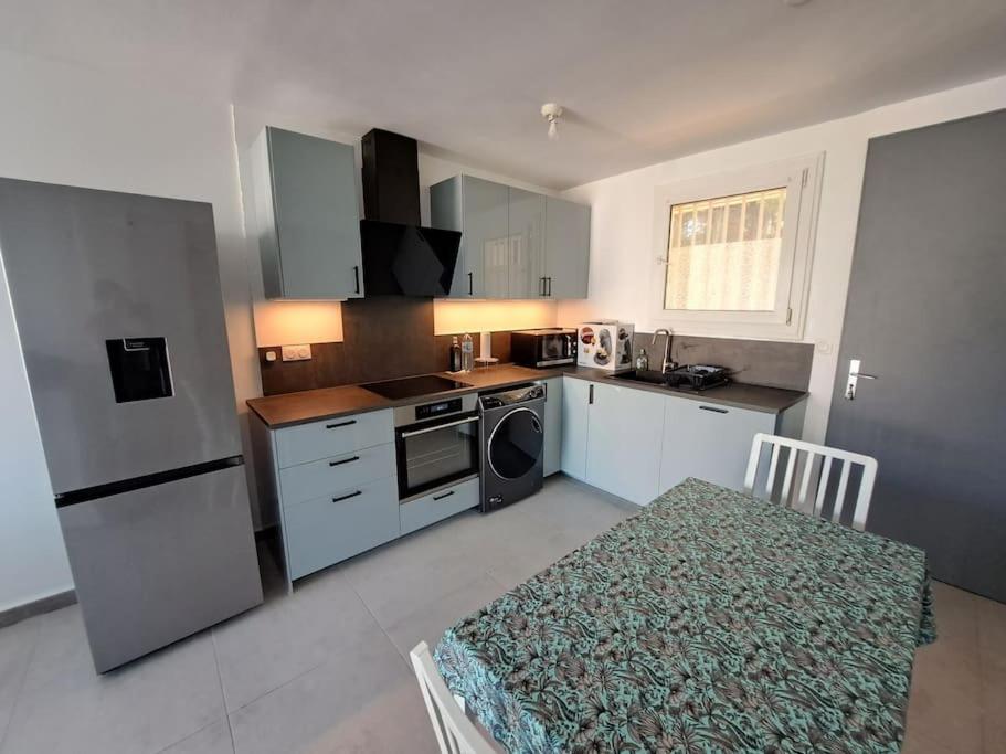 une cuisine avec un réfrigérateur et une table à l'intérieur dans l'établissement T4 65 m2, 3 chambres à Giens proche village, à Hyères