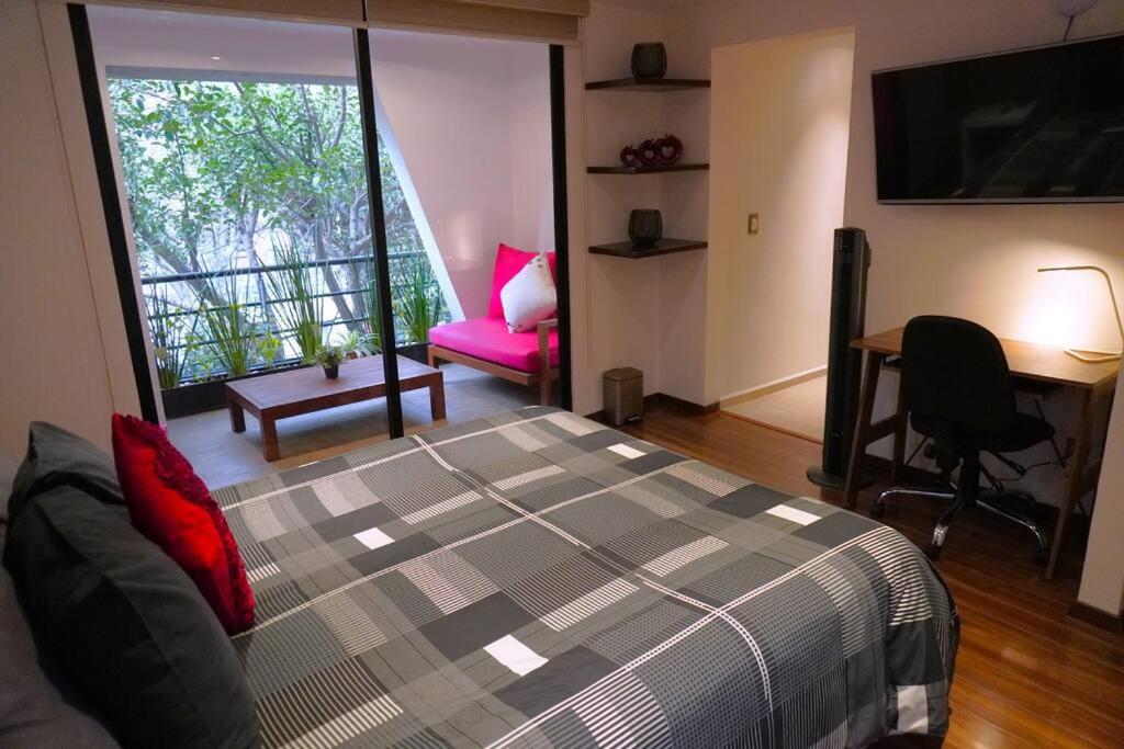 ein Schlafzimmer mit einem Bett, einem Schreibtisch und einem Stuhl in der Unterkunft Loft con balcón en Roma Norte in Mexiko-Stadt