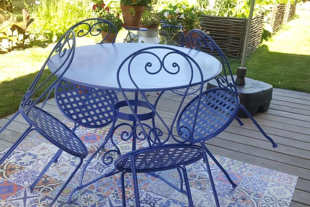 Appartement pour un couple, jacuzzi en été, jardin في جنيف: طاولة وكراسي عليها رسم للوجه