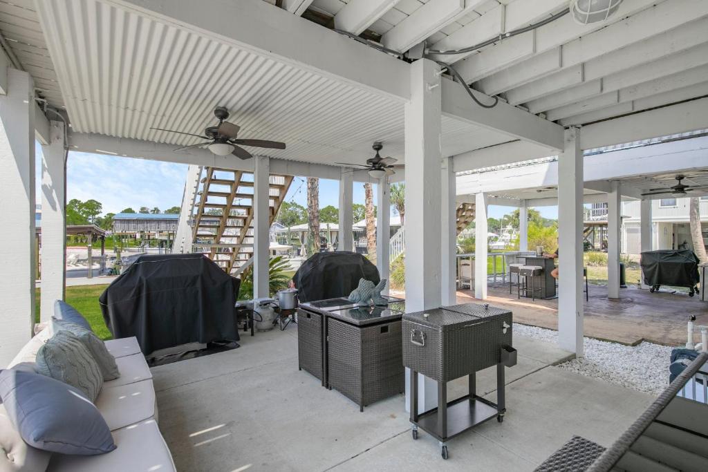 a covered patio with a couch and a table at Water front Getaway w. Boat Docks / Fishing in Orange Beach