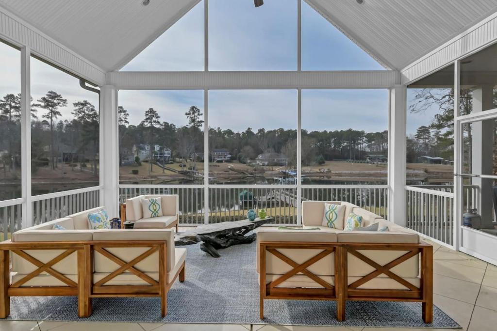 een grote afgeschermde veranda met 2 tafels en stoelen bij Luxury Escape by the Lake in Lexington