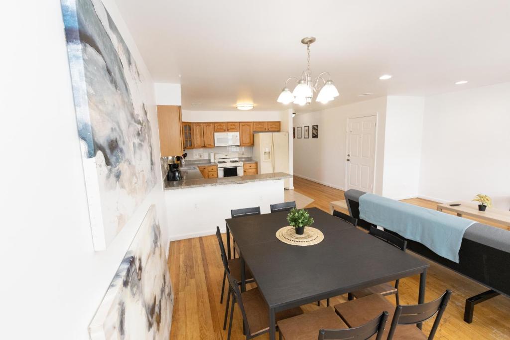 a dining room and kitchen with a table and chairs at Elegant & Spacious 3-bed Gem mins to NYC in Jersey City