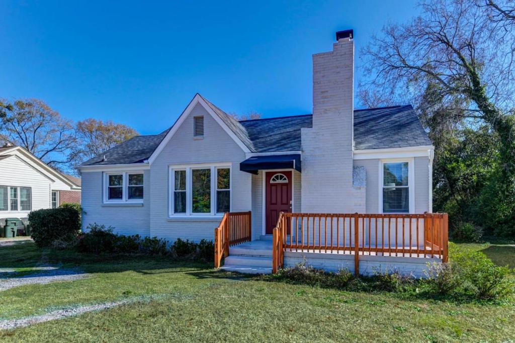 a white house with a wooden fence in front of it at Forest Acres Boho Home - 2BR in Columbia
