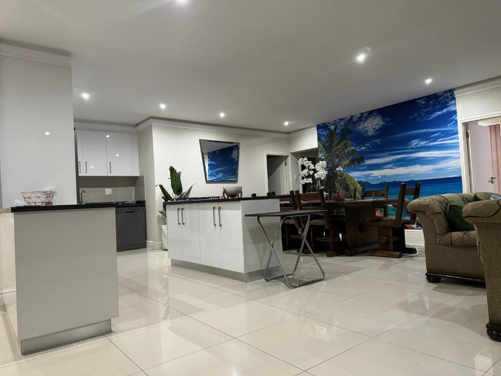 a kitchen and living room with a table and chairs at 17 Santana Pebbles Penthouse in La Mercy