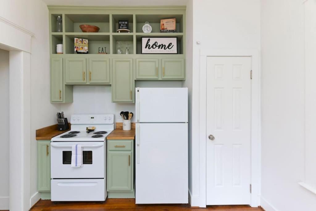 cocina con armarios verdes y nevera blanca en Melrose Heights 1BR, en Columbia