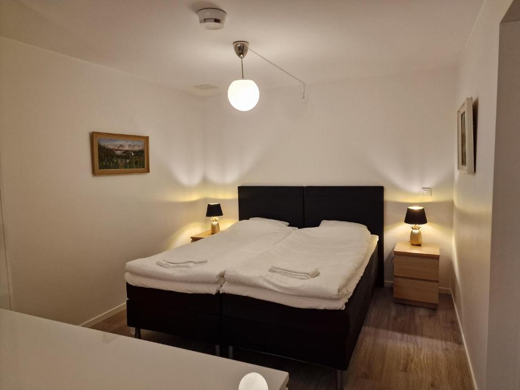 a bedroom with a bed and two night stands at Lägenhetshotell Varvet in Ellös