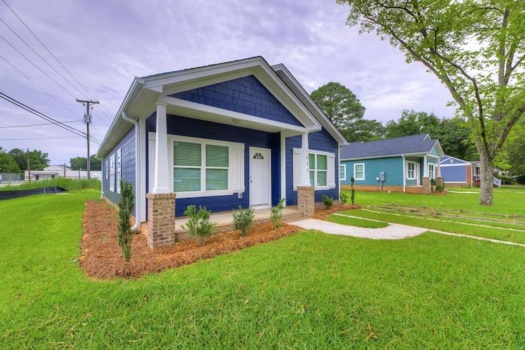 una pequeña casa azul con césped verde en Cayce Sister Houses-Sleeps 14 en Cayce