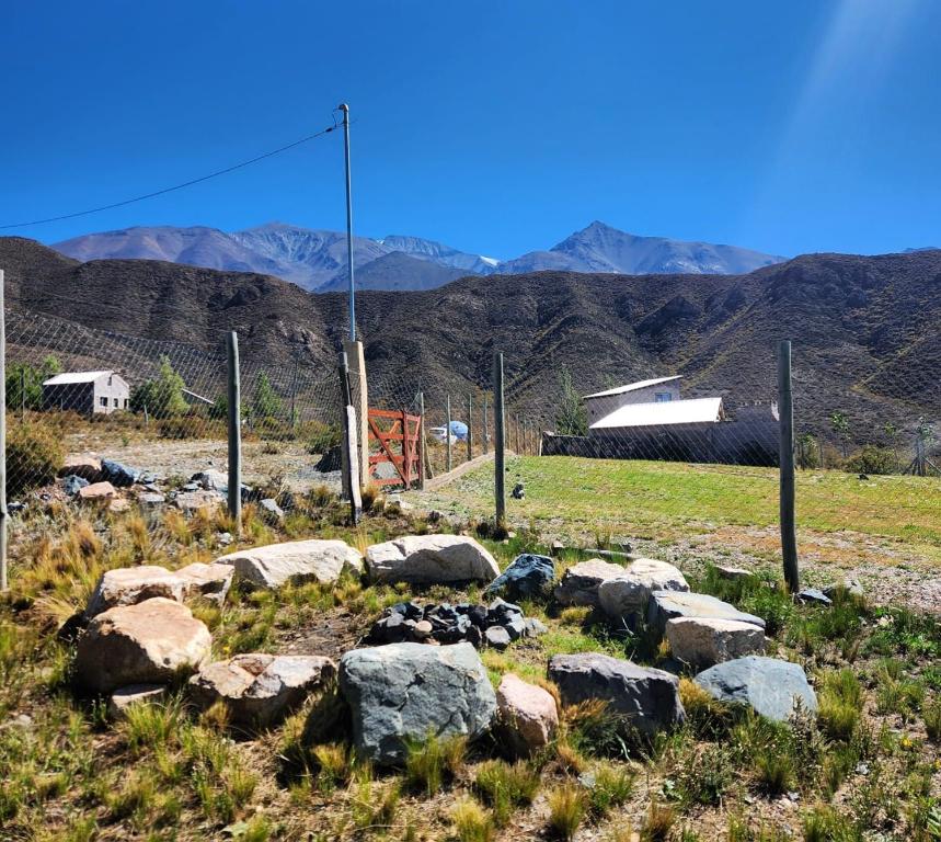 einen Haufen Steine auf einem Feld mit Bergen im Hintergrund in der Unterkunft la rosarina in Potrerillos