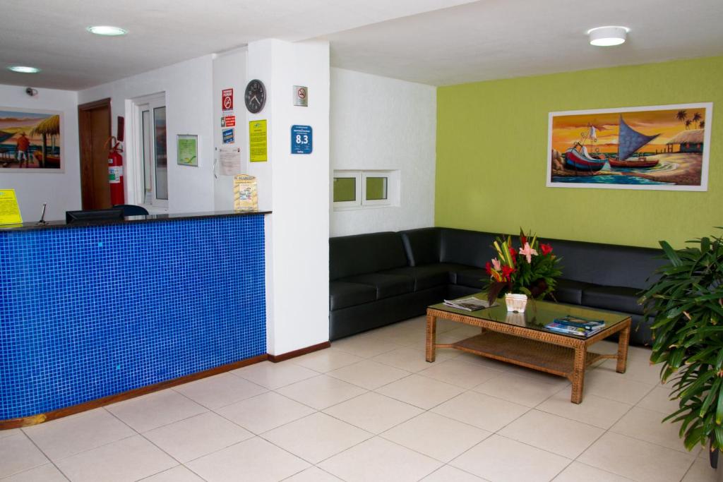 uma sala de espera com um sofá e uma mesa em Saint Patrick Praia Hotel em Maceió