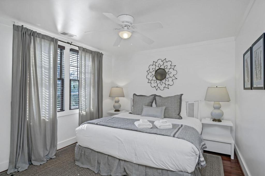 a white bedroom with a bed and a window at Historic Carriage House in Columbia