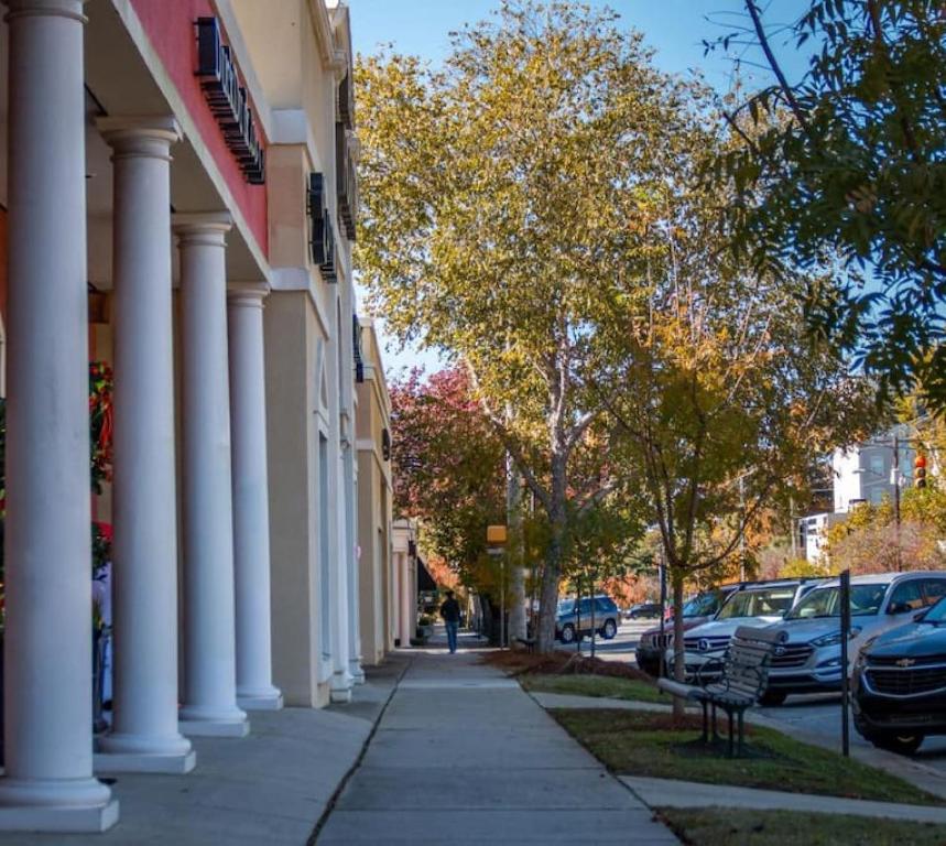 a city street with white columns and cars parked at Stylish and Cozy Apartment in Columbia