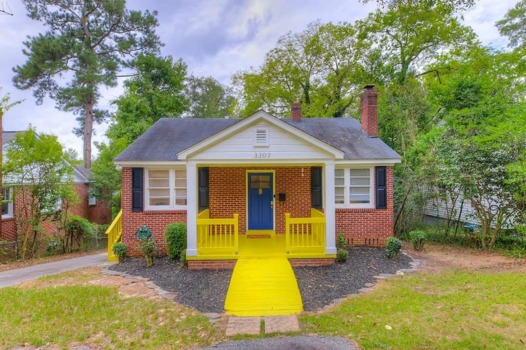een klein huis met een gele voordeur bij Charming Earlewood Cottage in Columbia
