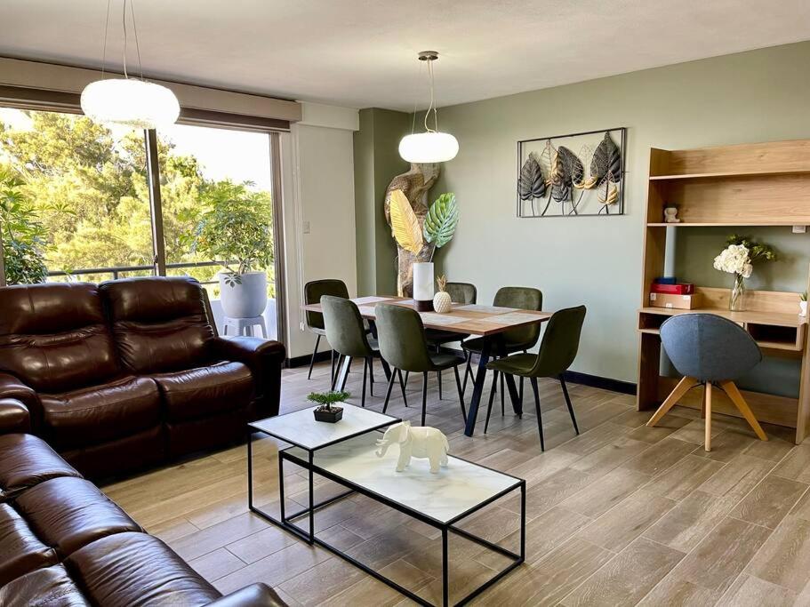 ein Wohnzimmer mit einem Sofa und einem Tisch in der Unterkunft Lovely 3-bedroom rental unit with free parking in Guatemala