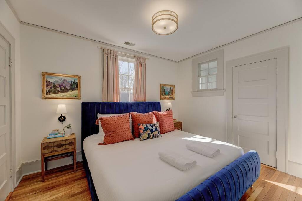 a bedroom with a large bed with a blue headboard at The Jewel of Bull St. Upstairs in Columbia