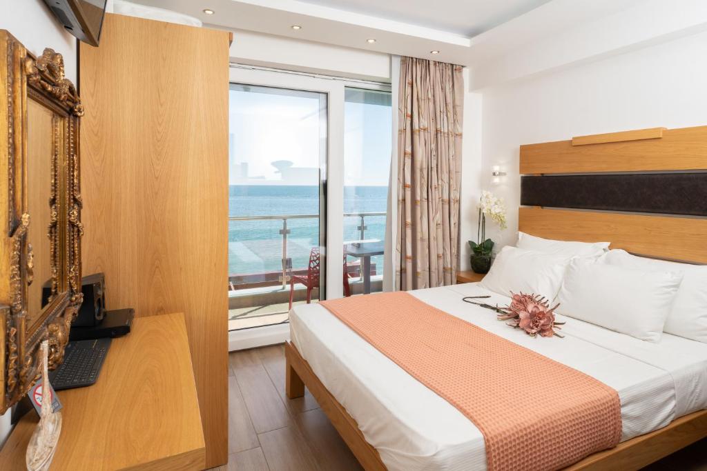 a hotel room with a bed and a balcony at Megkas Theodoros in Paralia Katerinis