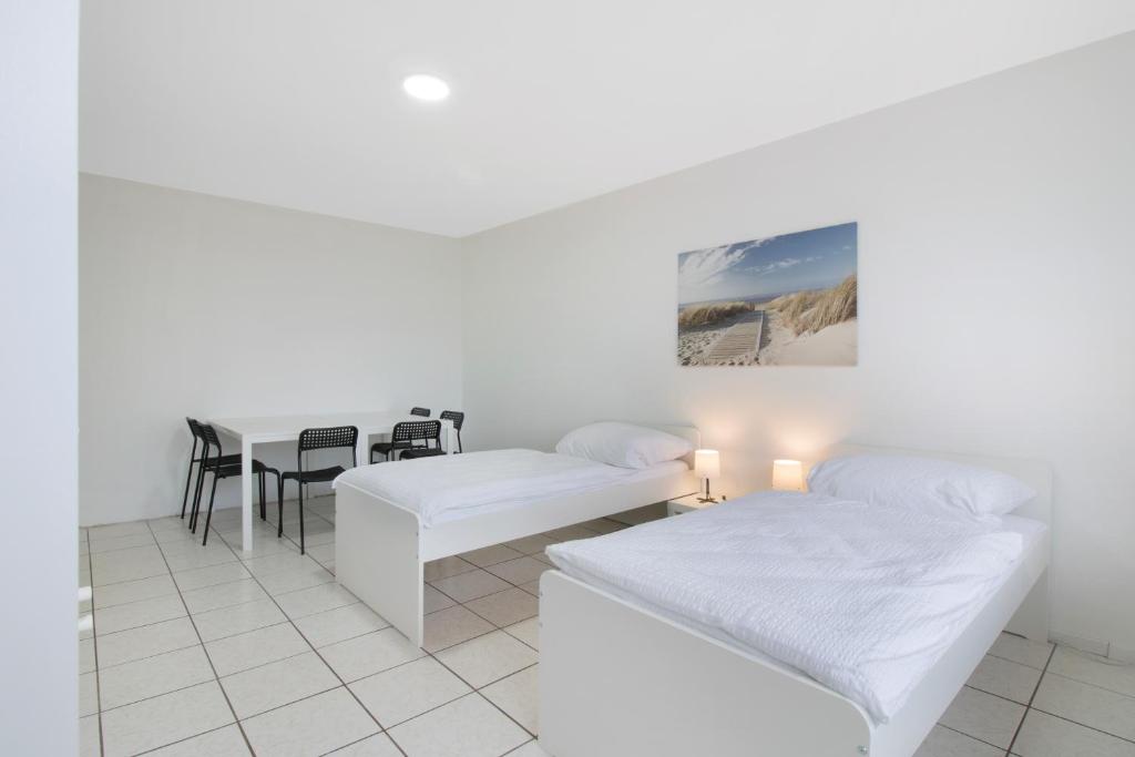 a white room with two beds and a table at Apartment mit Balkon in Witten in Witten