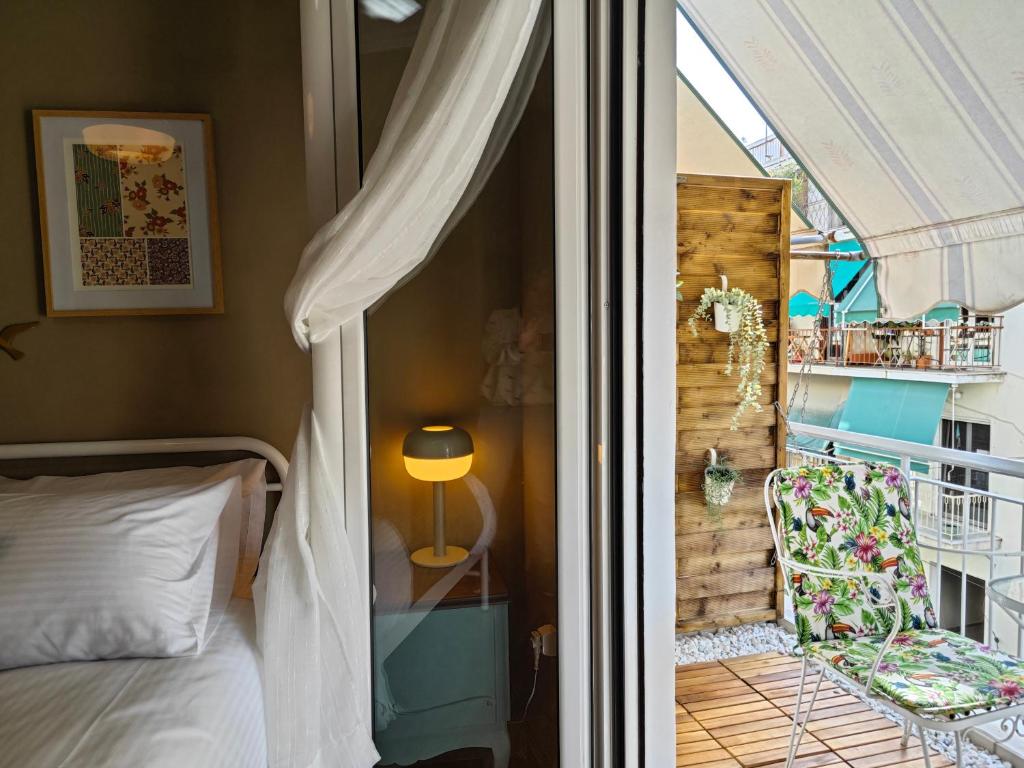 a bedroom with a balcony with a bed and a chair at Caravin Wanderhome Acropolis, 1 min from Acropolis Museum in Athens