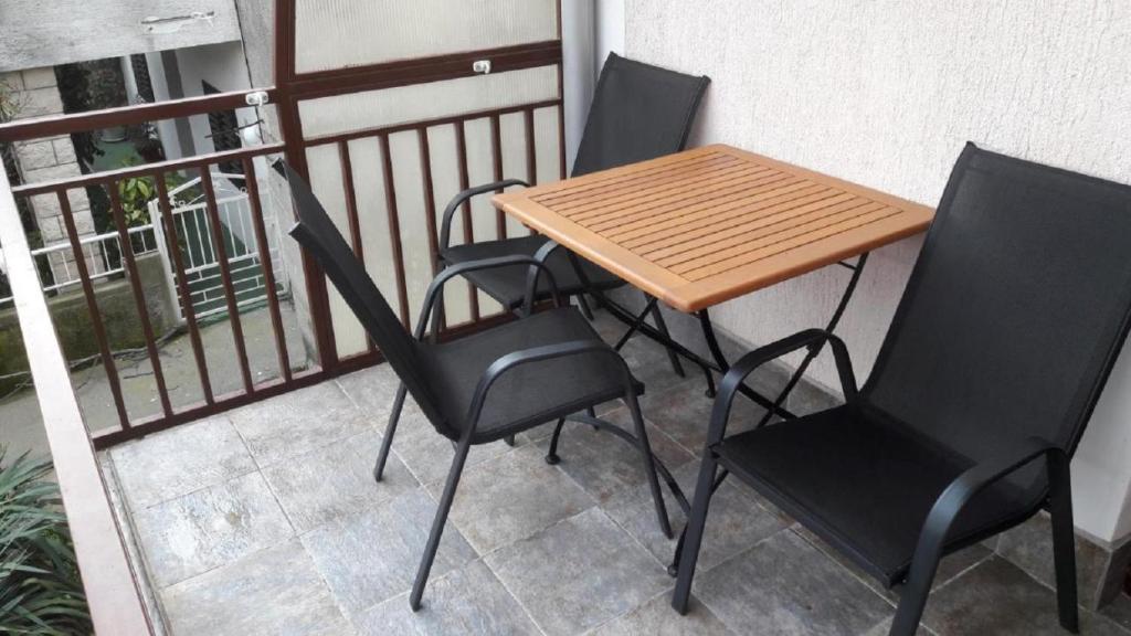 een houten tafel en stoelen op een balkon bij Apartment ZlataV - 250 m from sea in Crikvenica