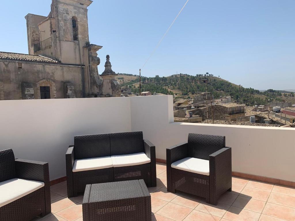 a balcony with chairs and a view of a city at Suoru Maria Apartments in Chiaramonte Gulfi
