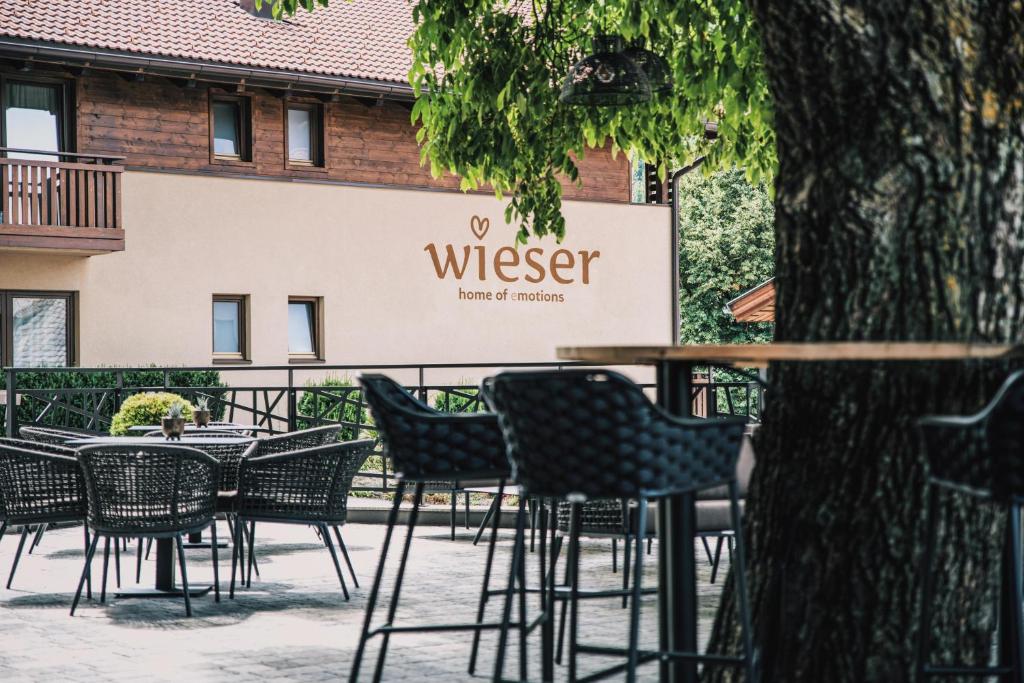 un grupo de mesas y sillas frente a un edificio en Hotel Wieser en Campo di Trens