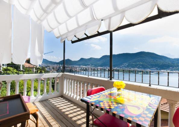 a table on a balcony with a view of the water at Apartment Como 54b in Como