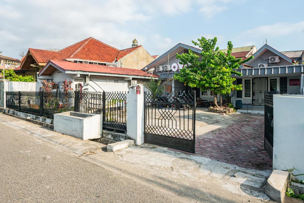 SUPER OYO Gandaria Guest House Near Masjid Raya Sumatera Barat في بادانج: بوابة امام المنزل