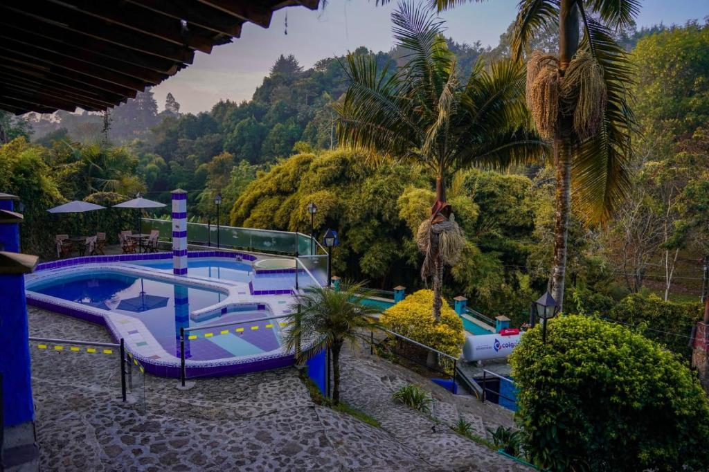 una piscina en un complejo con un tobogán en FINCA HOTEL SANTO TOMAS REAL en Rionegro