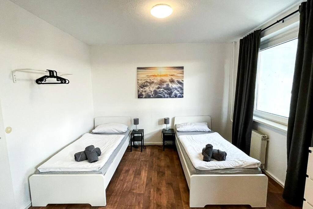 Habitación con 2 camas, mesa y ventana en Cosy flat with TV & WLAN in Halle, en Angersdorf