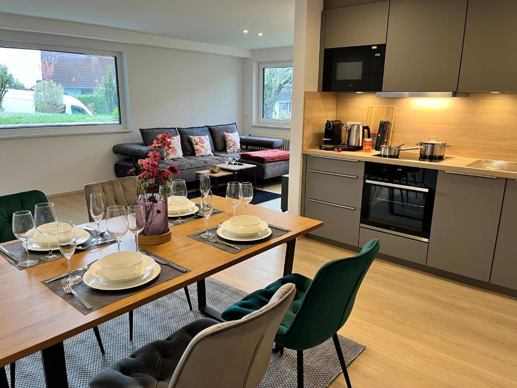 eine Küche und ein Wohnzimmer mit einem Tisch und Stühlen in der Unterkunft LIMA FeWo Apartment in Friesenheim