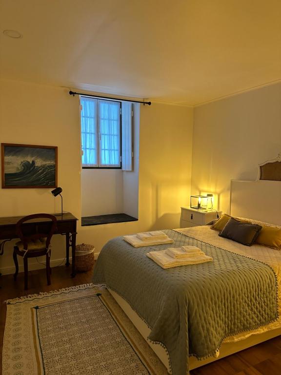 a bedroom with a bed and a desk and a window at Solar Nossa Senhora da Conceição in Capelas