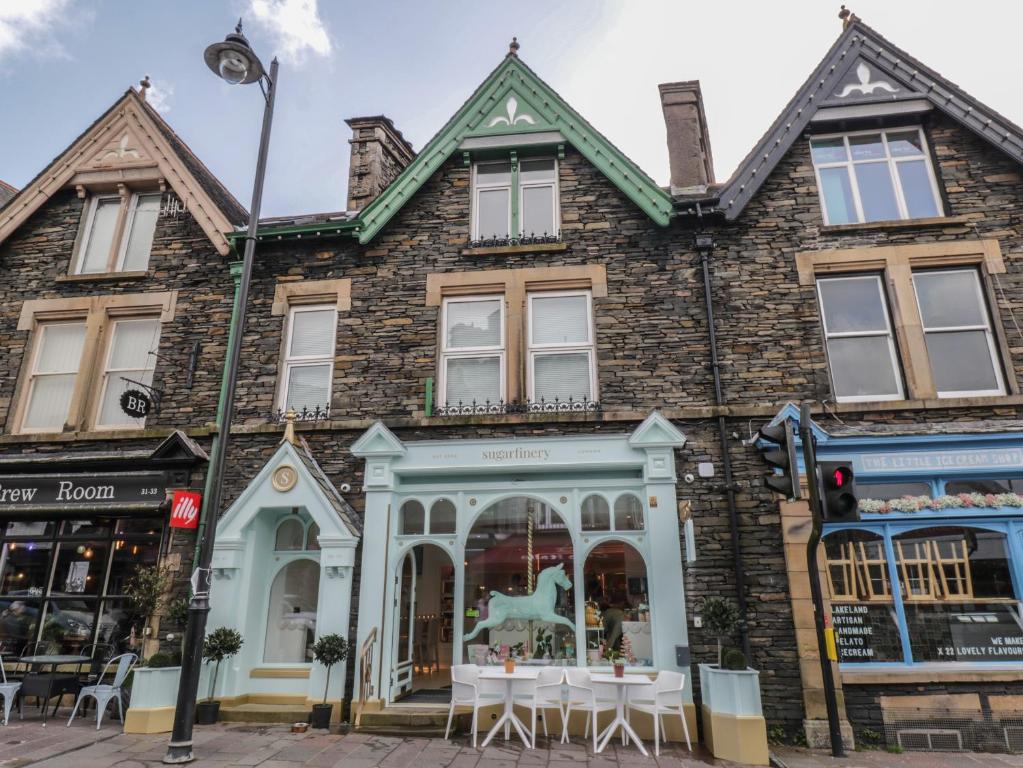 a building with tables and chairs in front of it at Windermere Crescent in Windermere