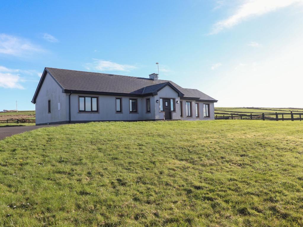 a house on top of a grassy field at 2 Ocean View in Doonbeg