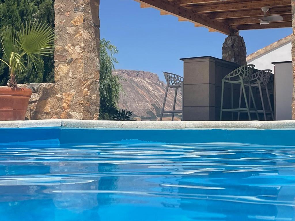 - une piscine dans une villa avec eau bleue dans l'établissement Casas Demi verhuurhuis, à Vélez-Blanco