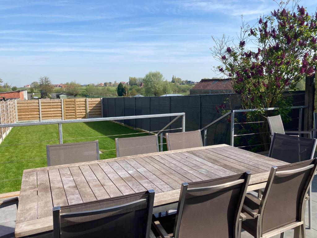 een houten tafel en stoelen op een patio bij Het Zonnetje Zonnebeke in Zonnebeke