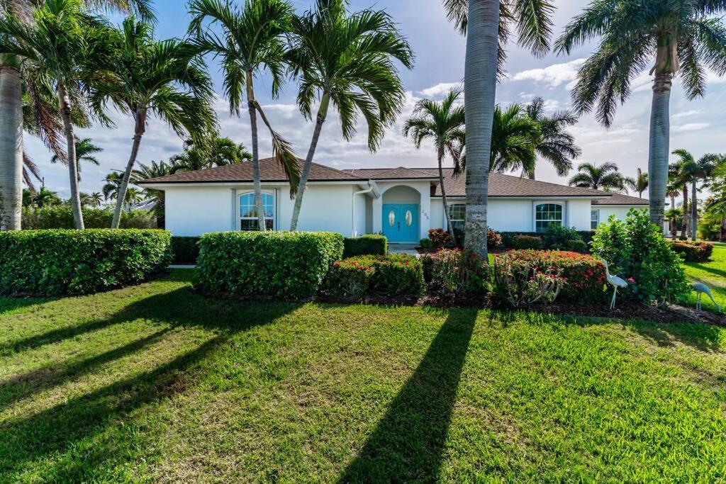 Your Ultimate Coastal Retreat في جزيرة ماركو: منزل فيه نخل قدام ساحة